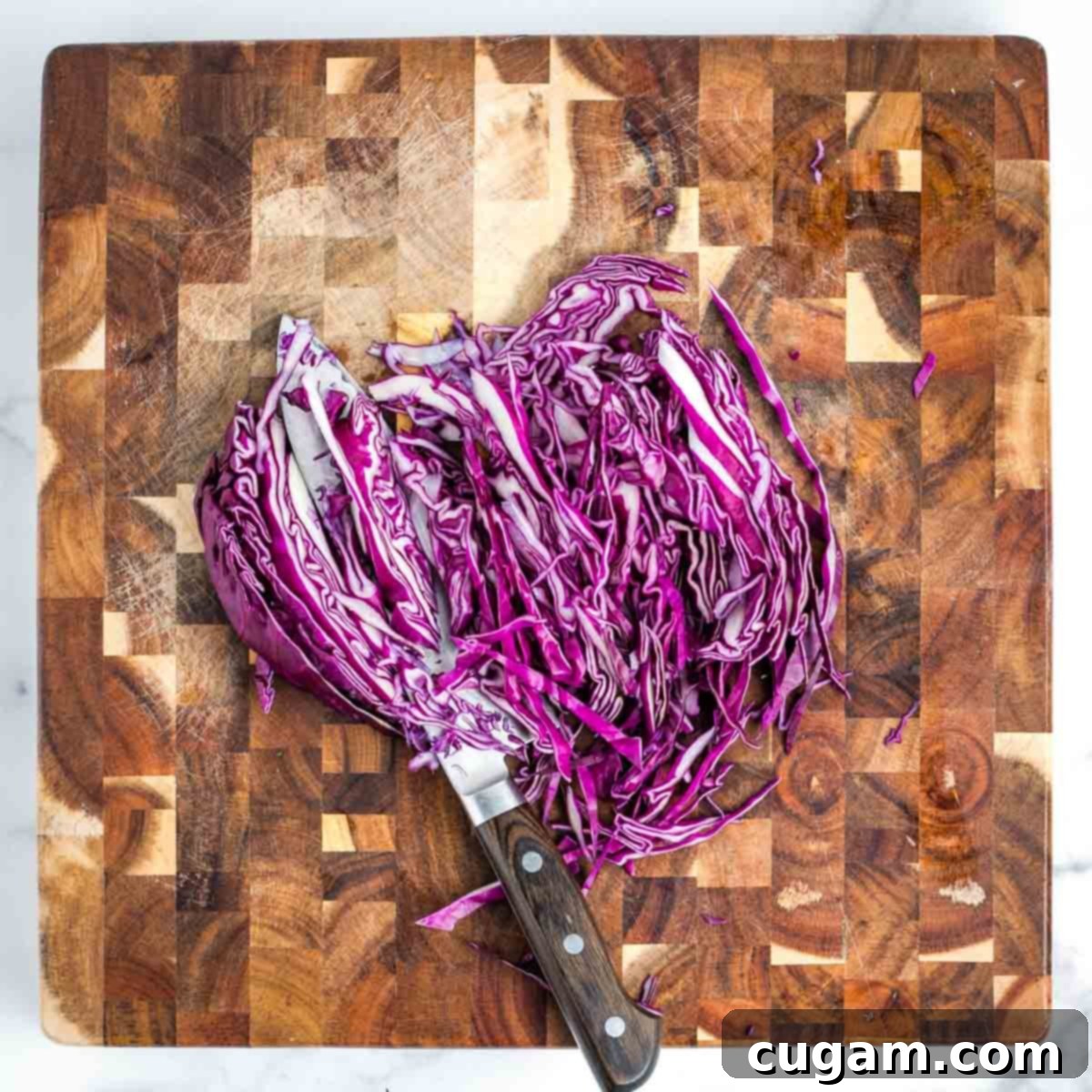 Effortless Vegan Potato and Veggie Skillet 8 Showing the technique for thinly slicing a quarter of a purple cabbage, creating fine ribbons.