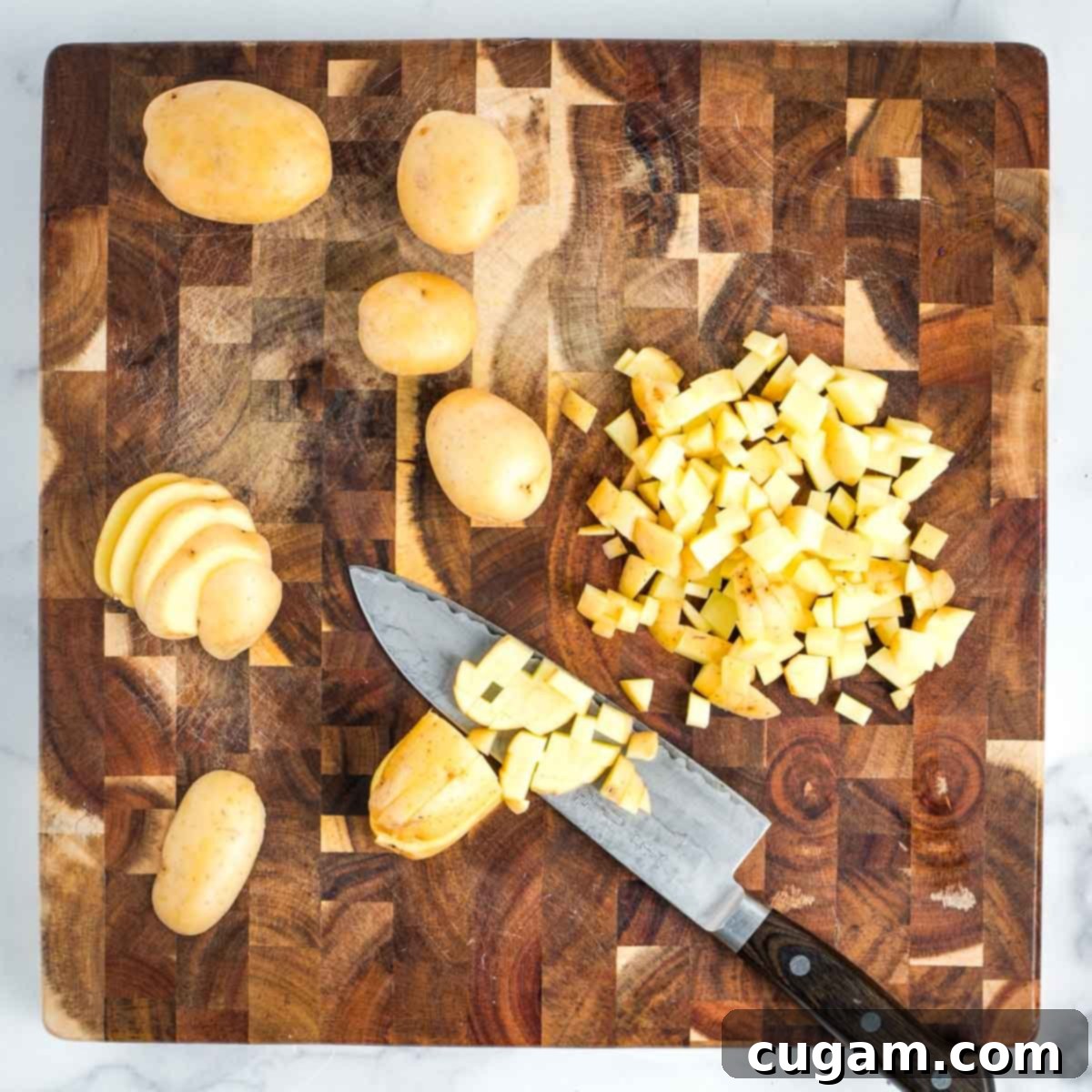 Effortless Vegan Potato and Veggie Skillet 9 Detail shot demonstrating how to dice Yukon Gold potatoes into uniform cubes.