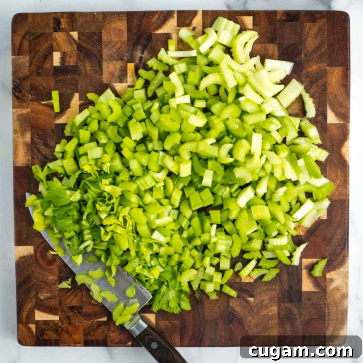 Cutting board full of chopped up celery.