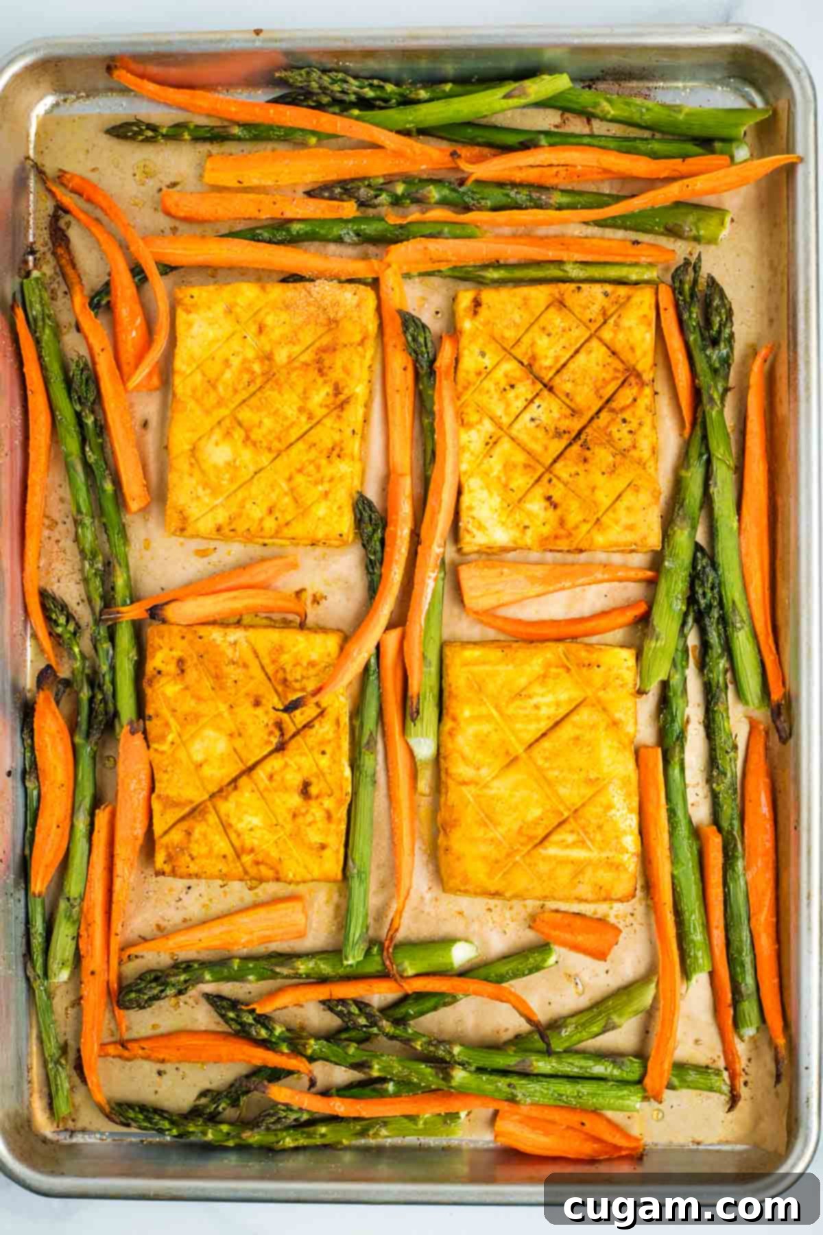 Roasted carrots, asparagus and tofu steaks on a sheet pan.