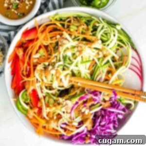 Zucchini noodles, carrot ribbons, red peppers, cabbage and radish with peanut sauce drizzled over and peanuts, scallions and jalapenos sprinkled on top.