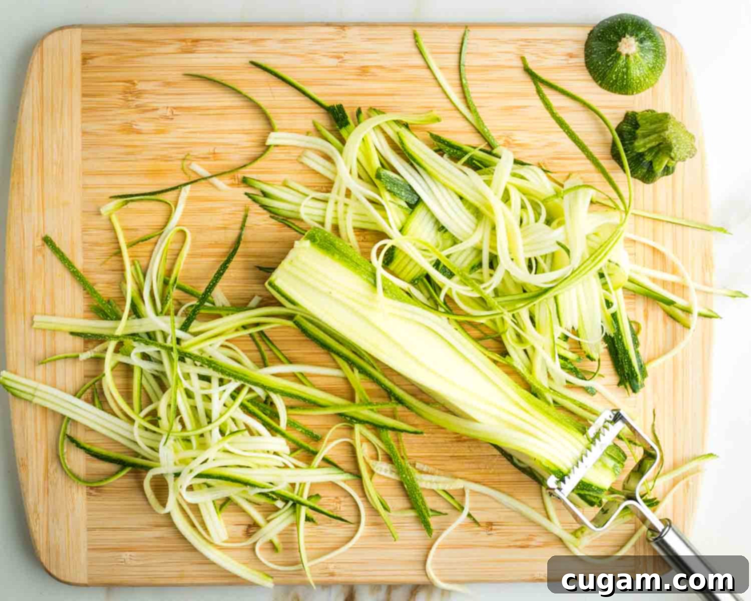 Julienne peeler making thin strips of zucchini.