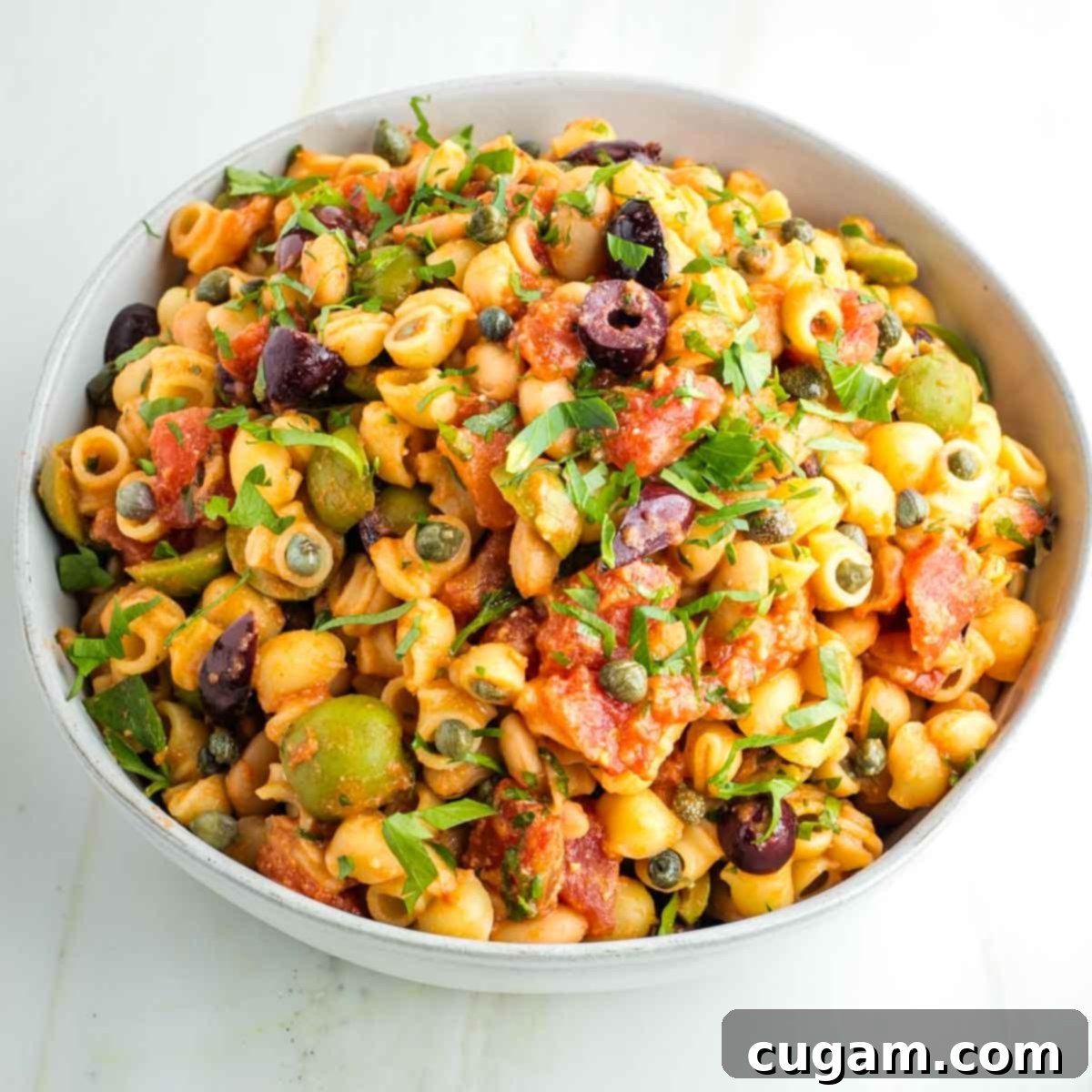 Close-up of a serving of White Bean Vegan Pasta Puttanesca, highlighting the diverse ingredients.