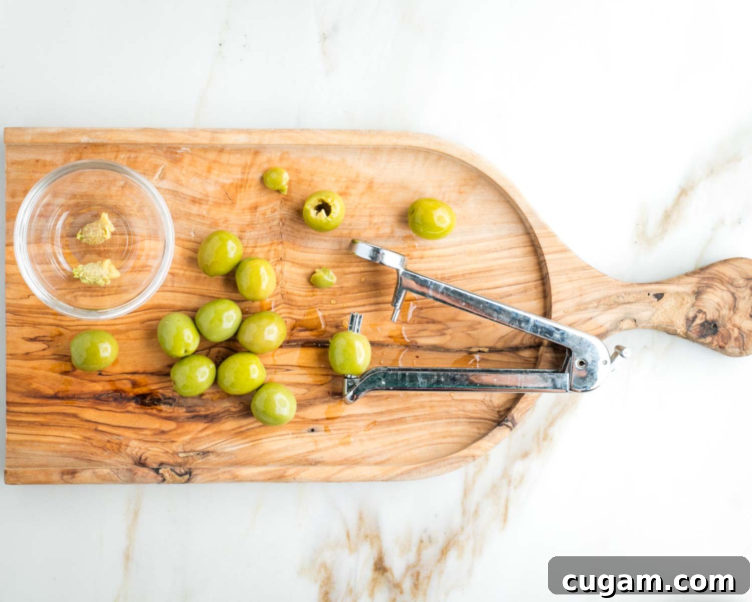 Olive pitter, removing pits from fresh Castelvetrano olives.