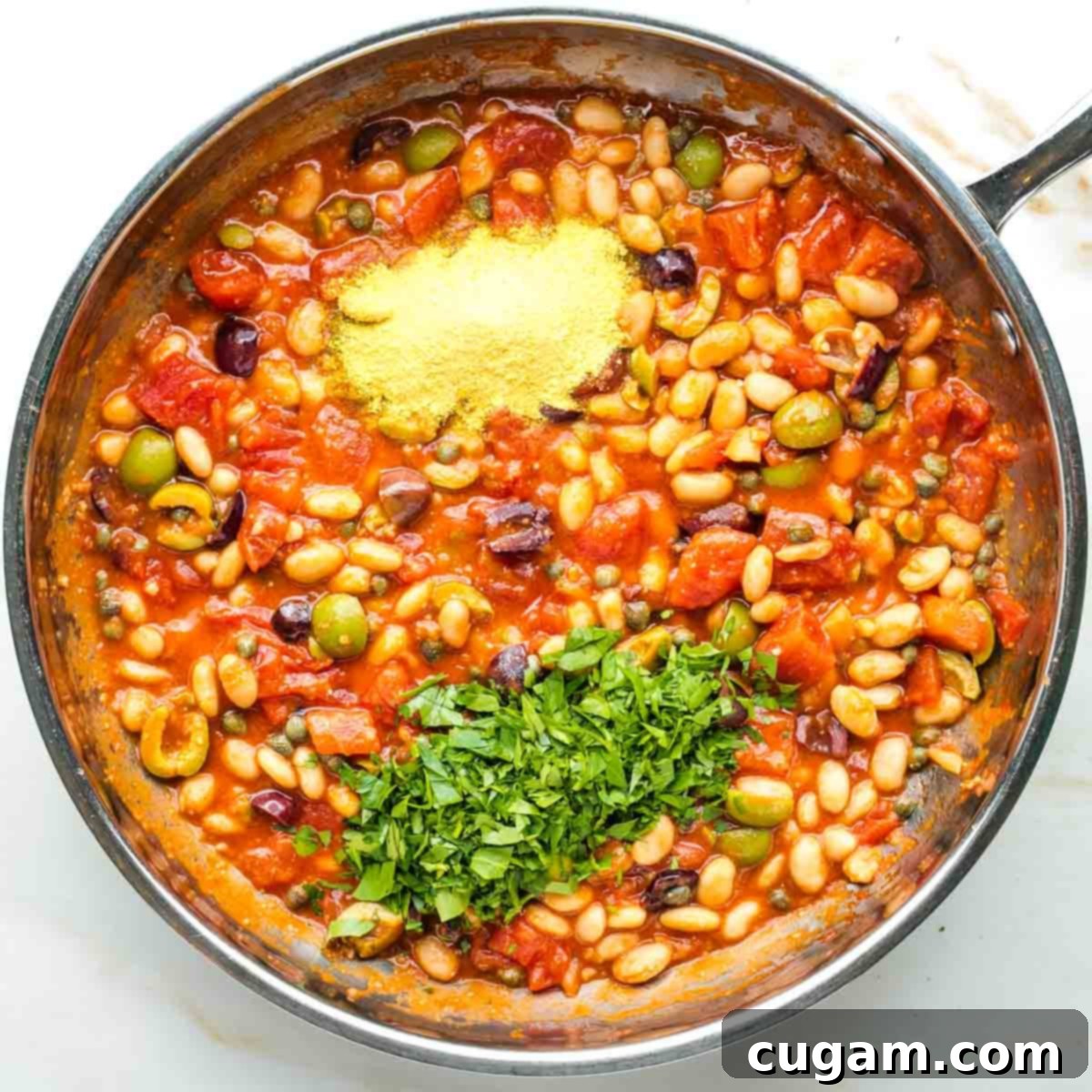 Nutritional yeast and fresh chopped parsley added to a chunky puttanesca sauce with white beans.