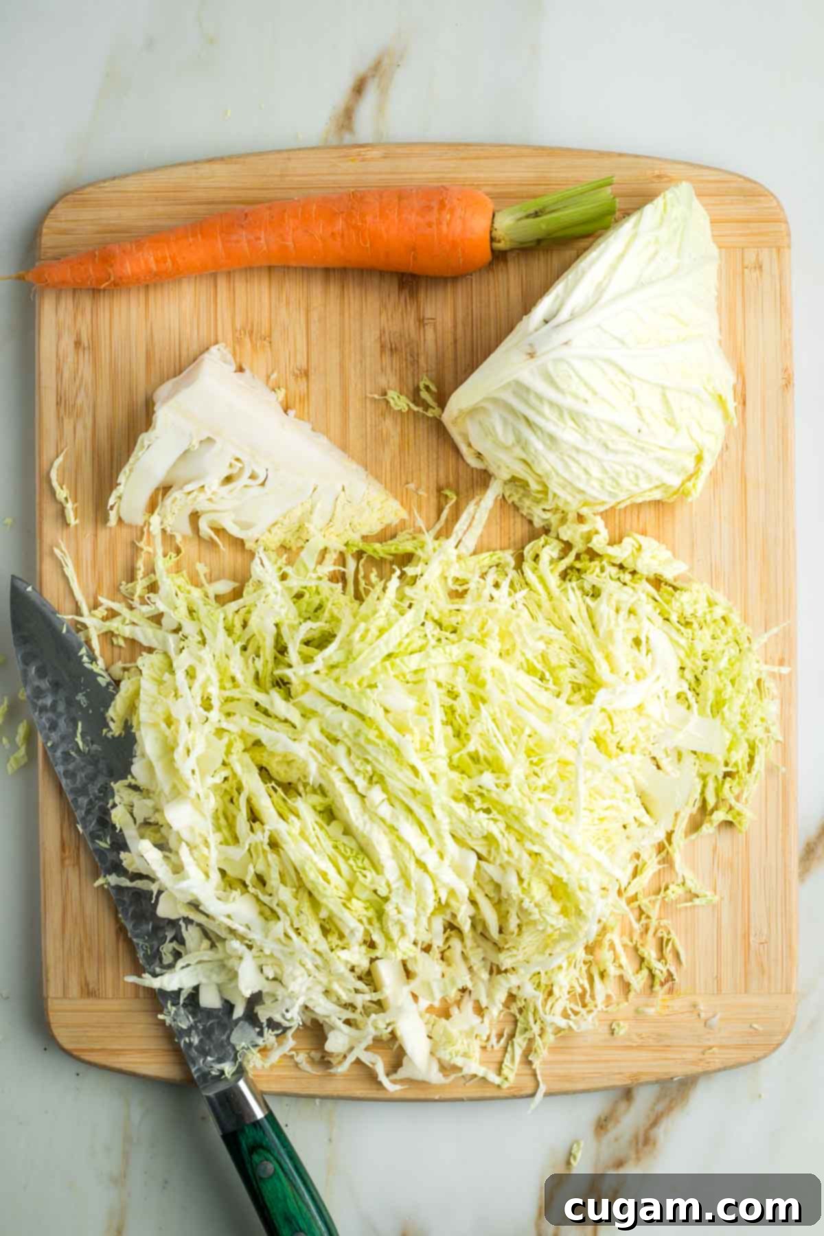 Zesty Russian Slaw 4 Thinly slicing cabbage from a half head on a cutting board.