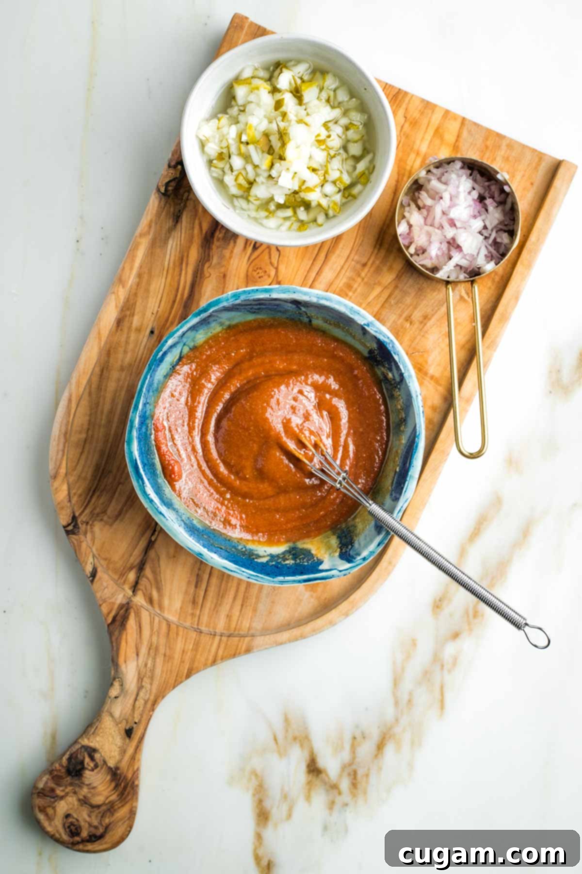 Zesty Russian Slaw 9 Whisking tomato paste into a tahini and tamari situation with diced pickles and shallot in small bowls off to the side.