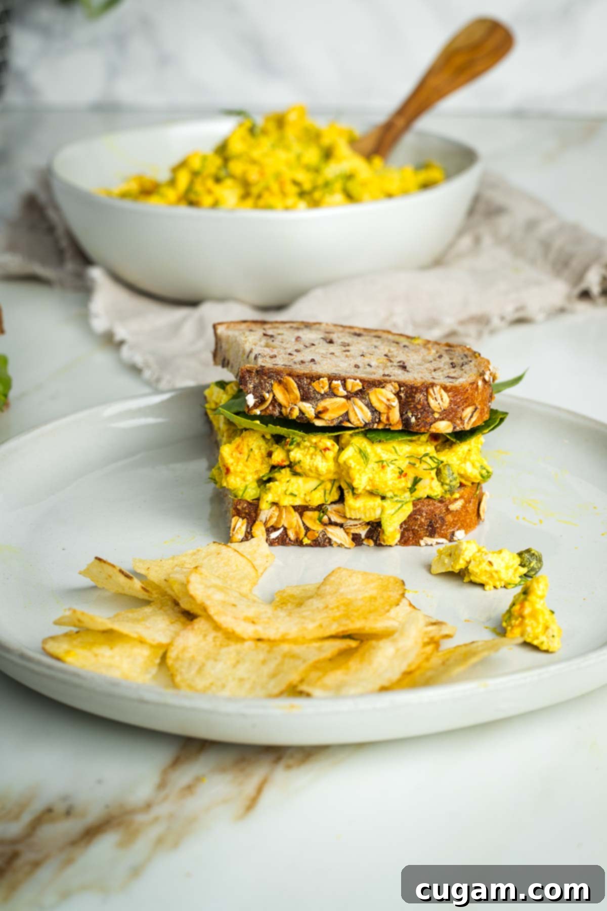 Half a vegan egg salad sandwich on sourdough with lettuce. 