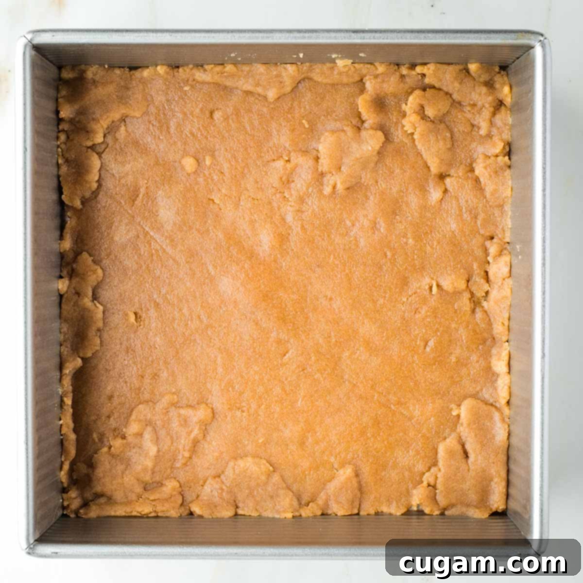 Pie crust pressed into an 8x8 inch square baking pan, with edges neatly patched.