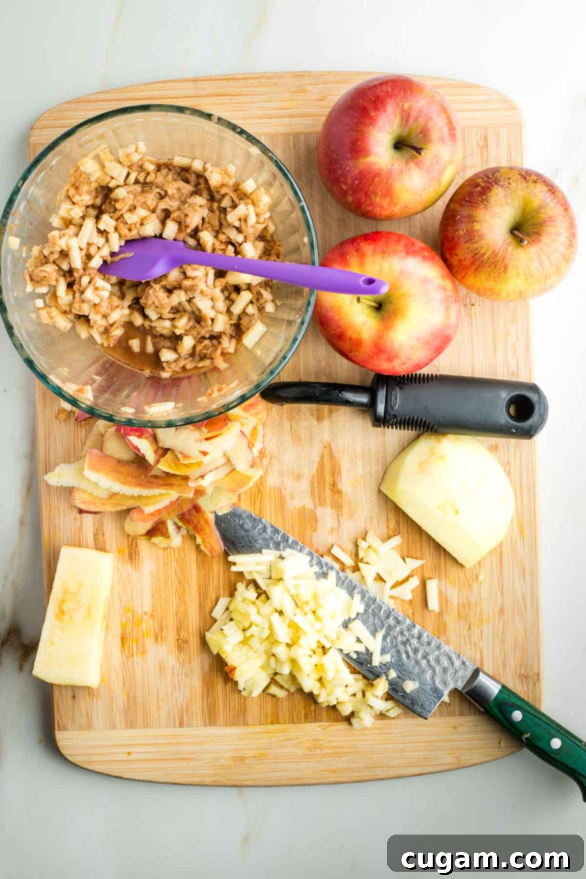 Dicing apples into small pieces and adding them to a bowl with the mixed spices in lemon juice.