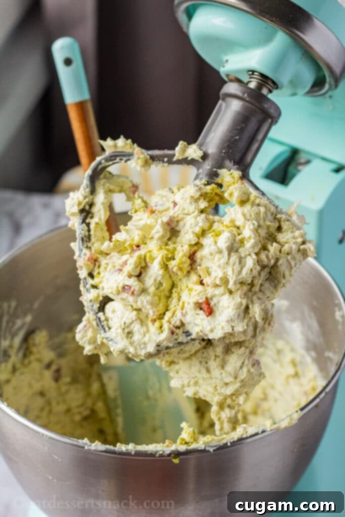 whipped cream cheese with bacon on paddle of stand mixer. 