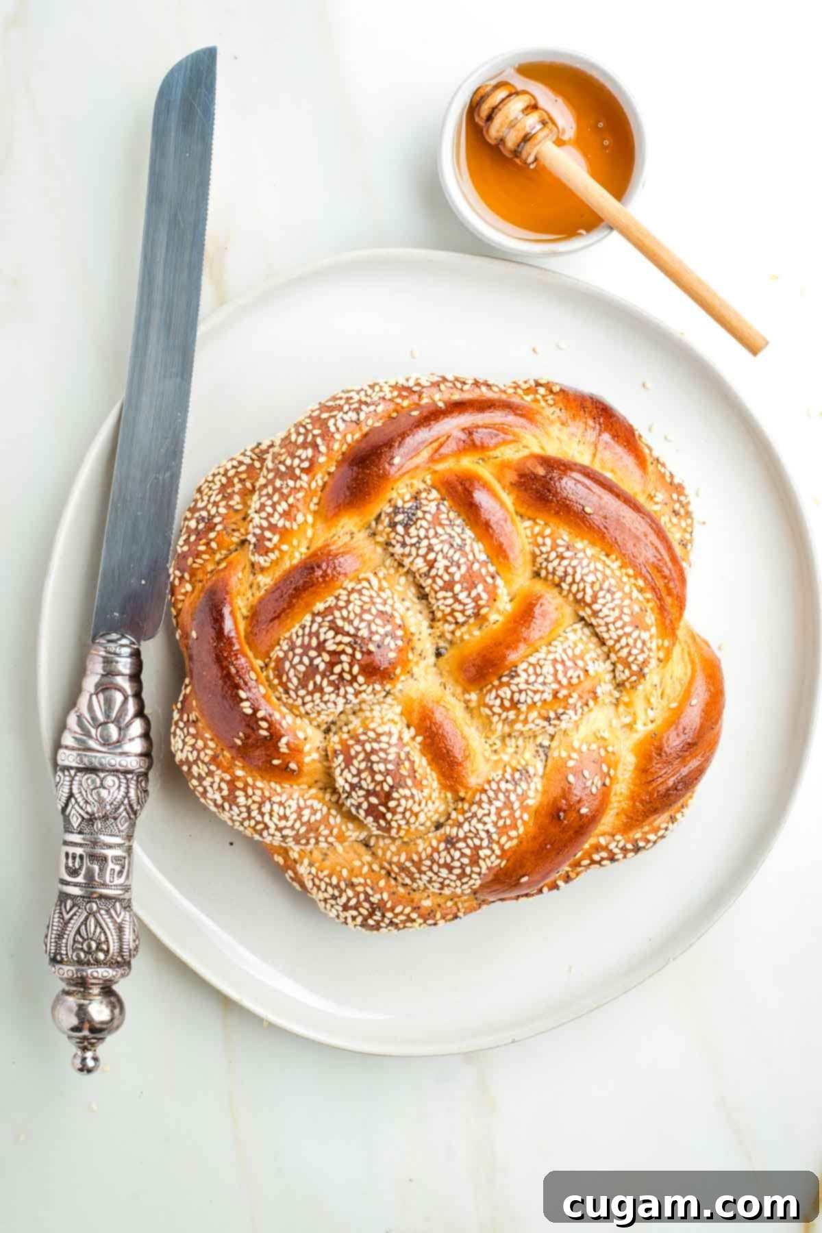 Golden Sweet Round Challah 2 Round, braided challah, sprinkle with seeds, a dish of honey plus a serrated challah knife.