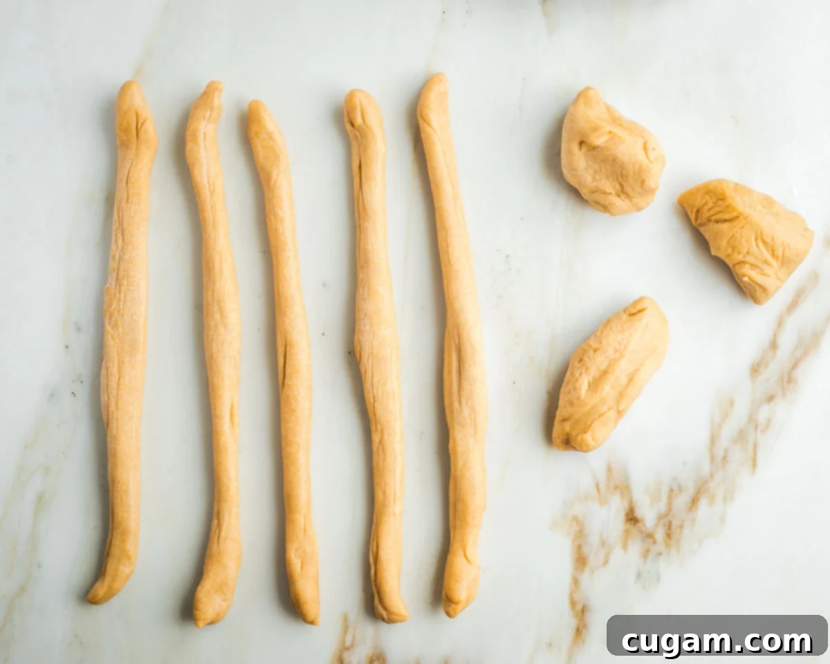 Golden Sweet Round Challah 23 Three pieces of dough and 5 strands of rolled out rope like lengths of dough.
