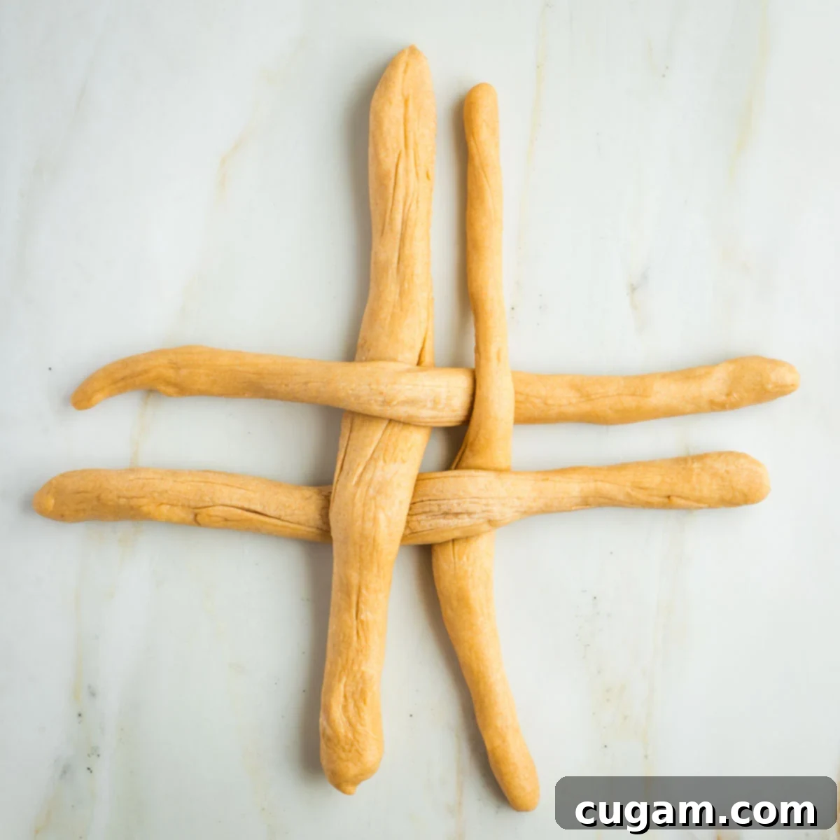 Golden Sweet Round Challah 33 4 strands of dough, 2 horizontal, 2 vertical in a criss cross pattern.