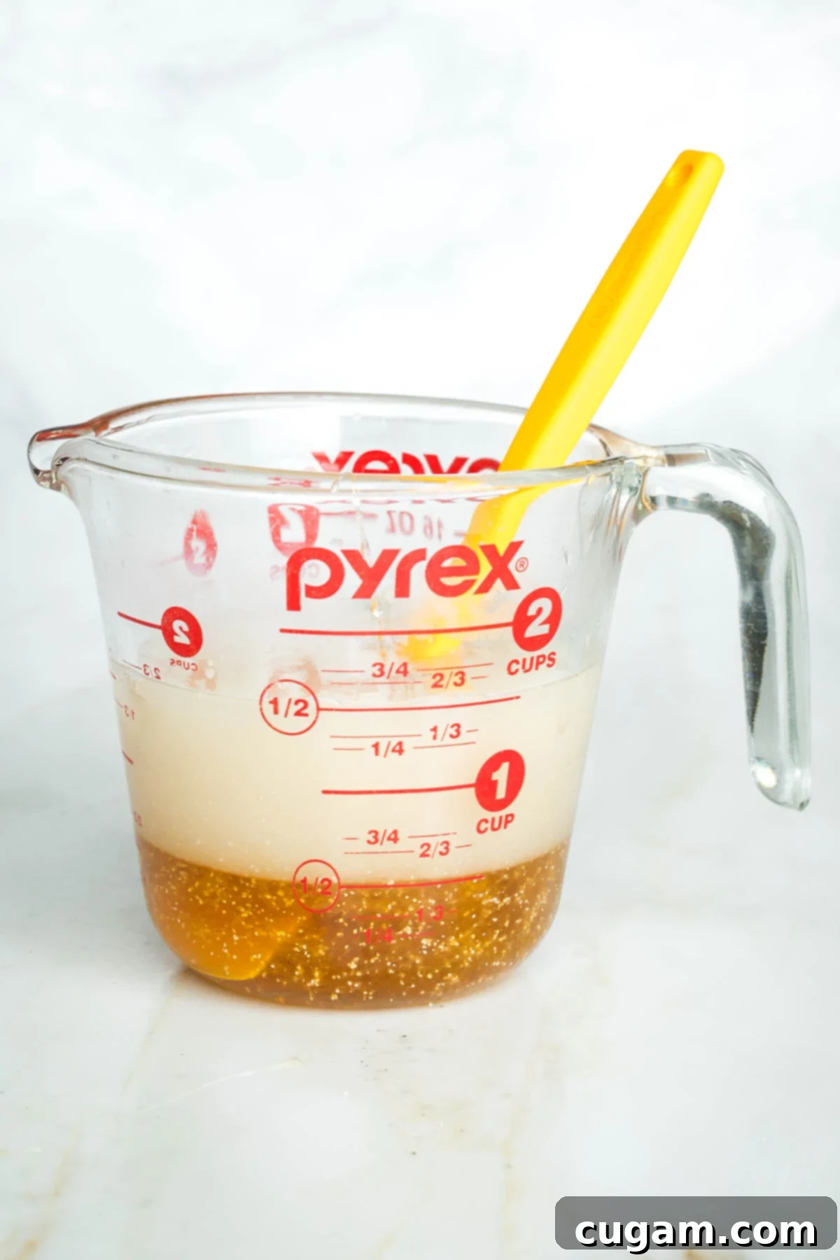 Golden Sweet Round Challah 5 Side view of a glass cup with water, honey and yeast proofing.