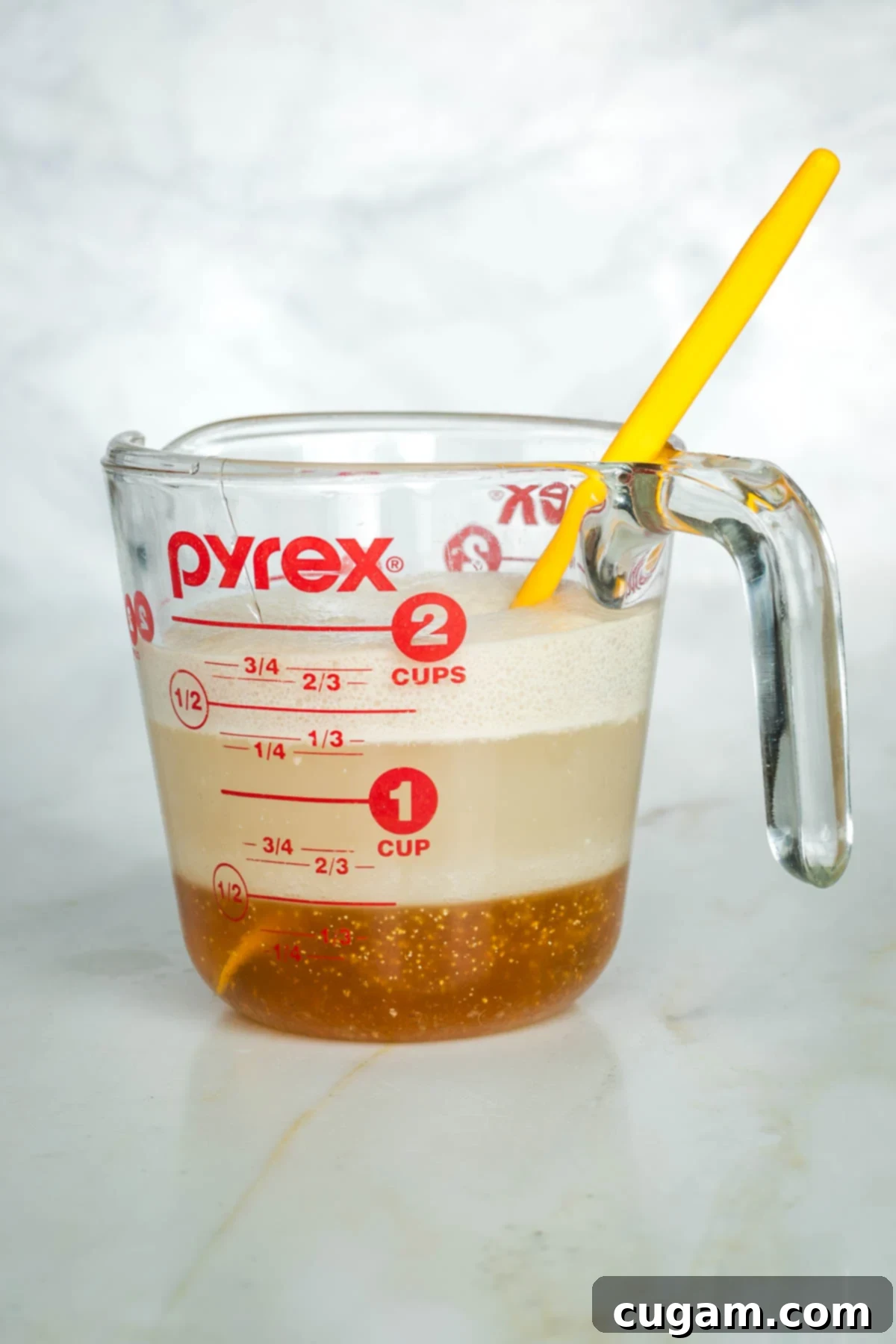 Golden Sweet Round Challah 6 Side view of yeast, honey and water proofing in a glass measuring cup.