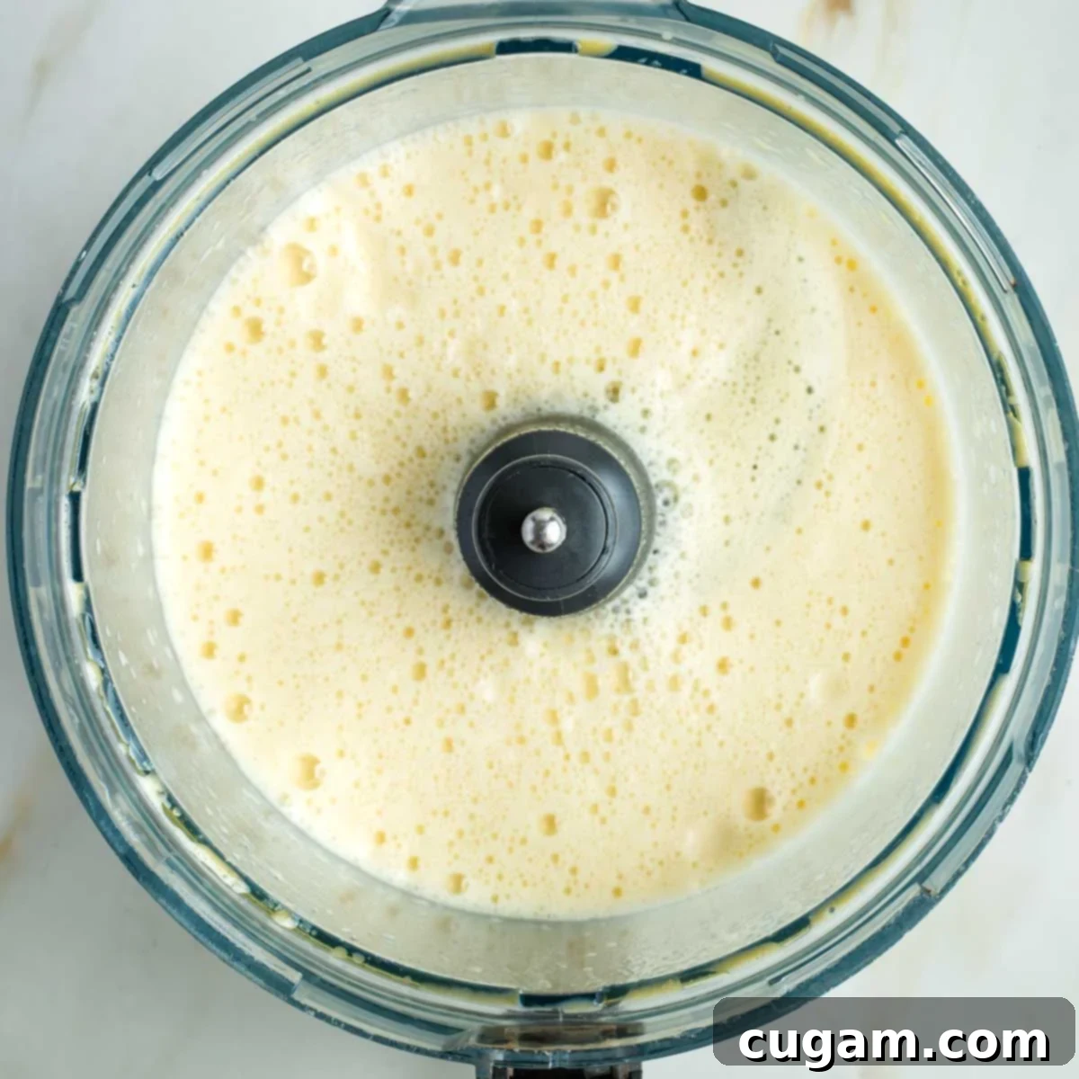 Golden Sweet Round Challah 10 Frothy eggs, oil and yeast mixture in the bowl of a food processor.