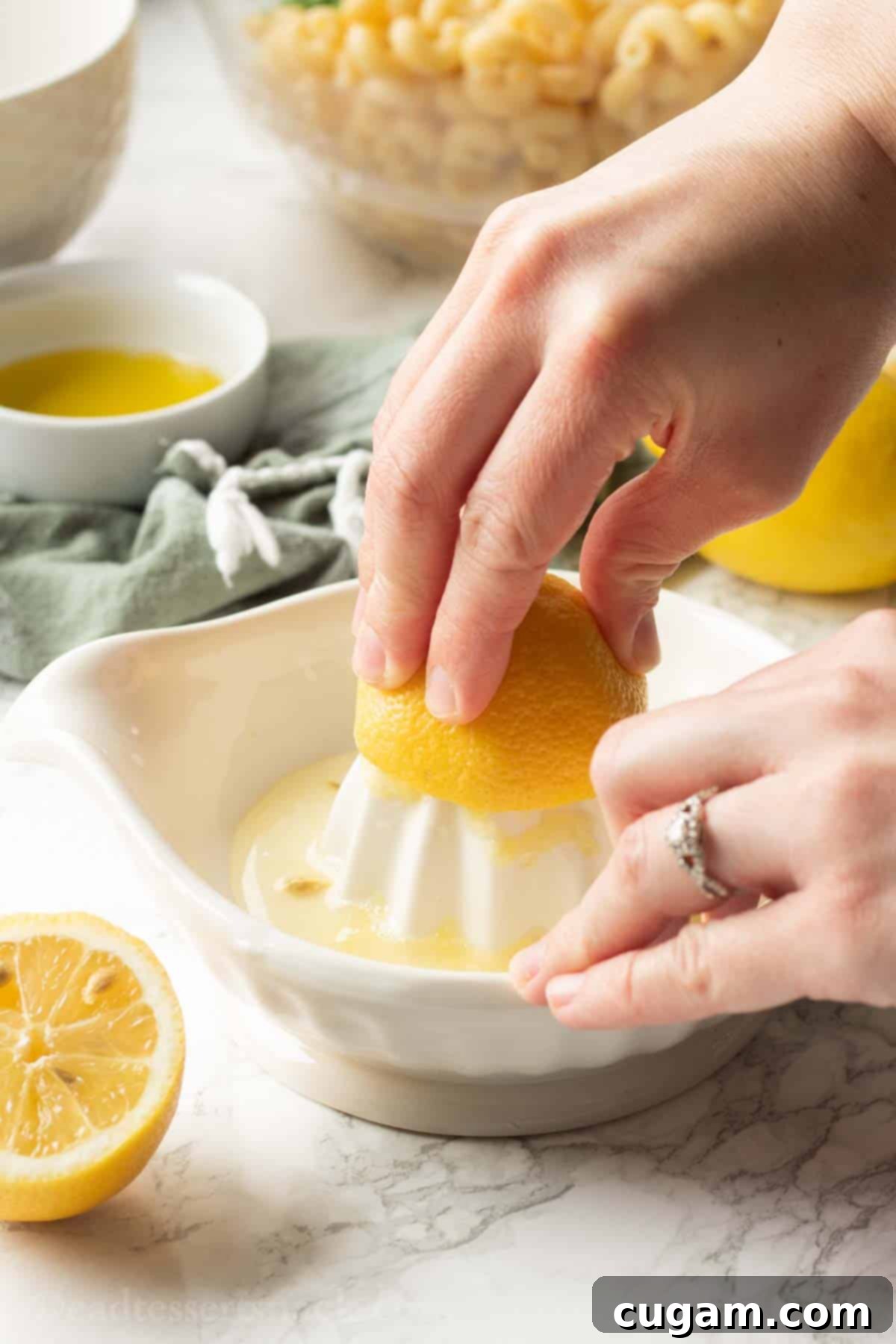 Squeezing fresh lemon juice from a half lemon into a small white bowl.
