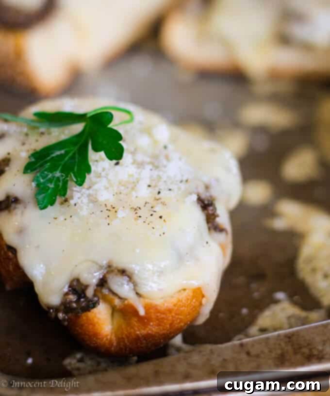 Golden brown toasts with melted Fontina cheese and a sprinkle of fresh parsley on a baking sheet.