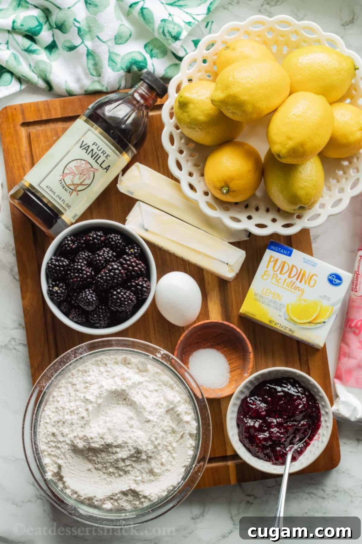 Ingredients for lemon blackberry cookies on wood cutting board. 