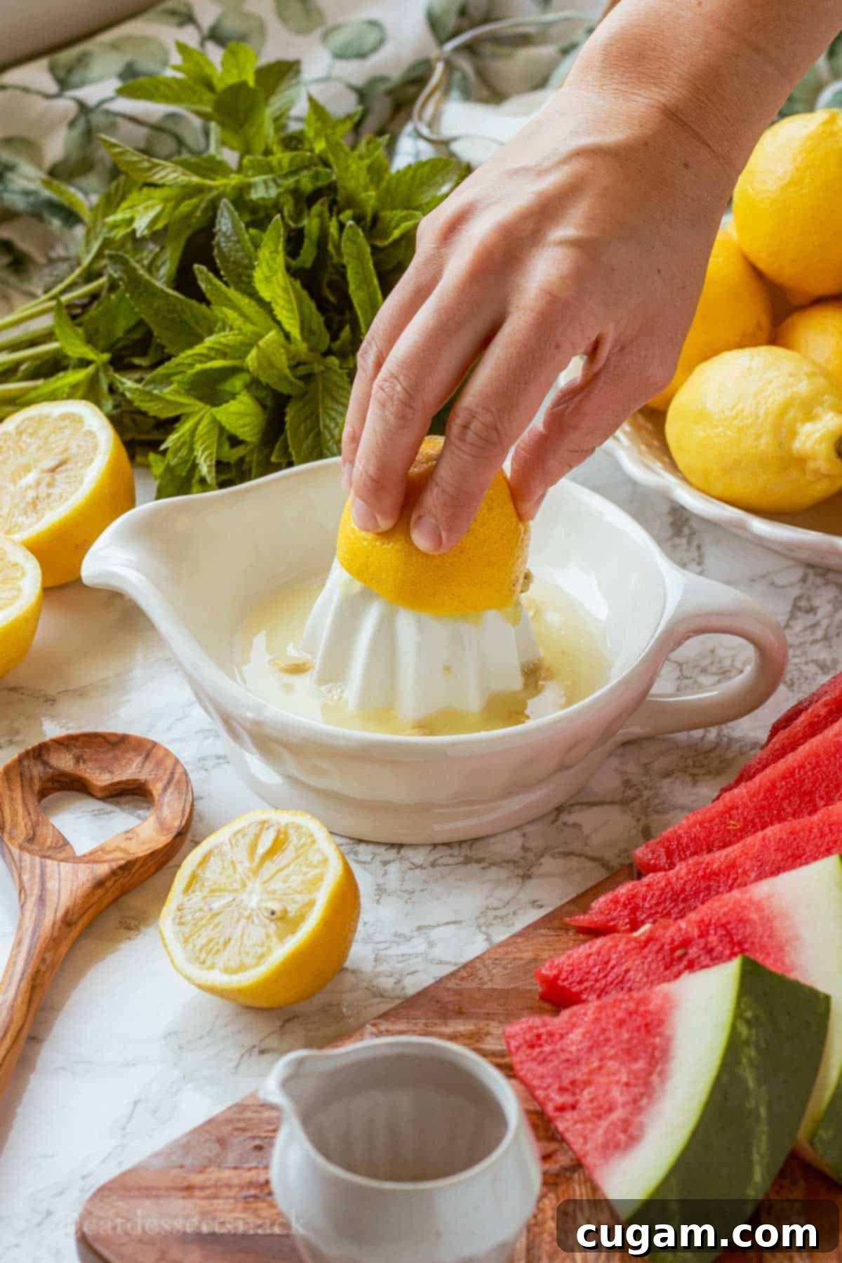 Hand squeezing lemon into a white bowl of lemon juice.