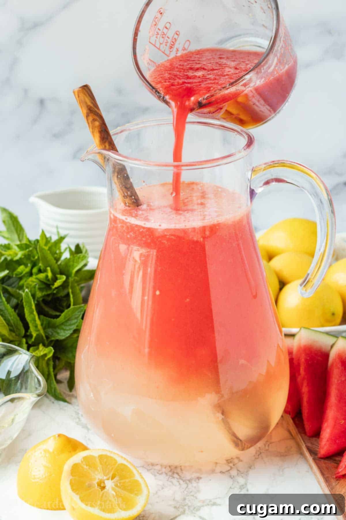 Pouring watermelon juice into pitcher of water and lemon juice.