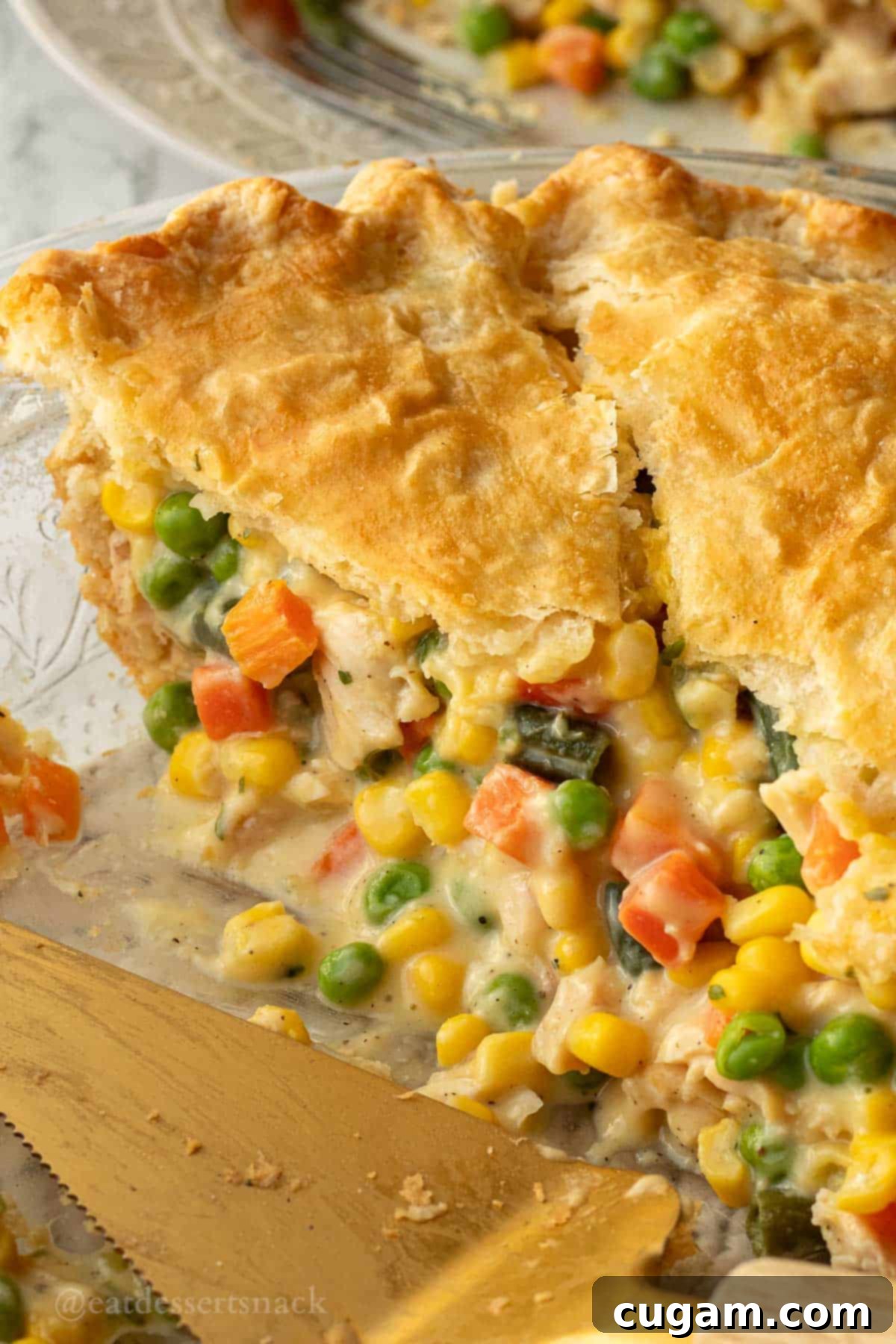 Quick Chicken Pot Pie 11 Slices of chicken pot pie in pie in glass pie dish with gold spatula.