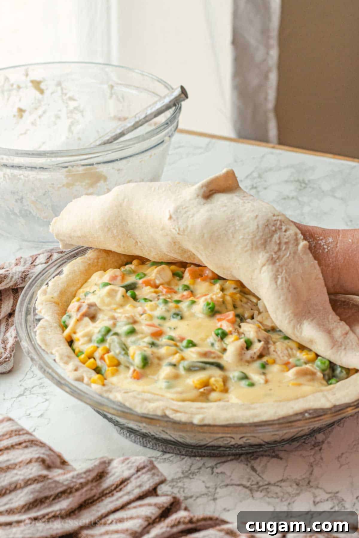 Quick Chicken Pot Pie 9 Laying raw pie crust over chicken pot pie.