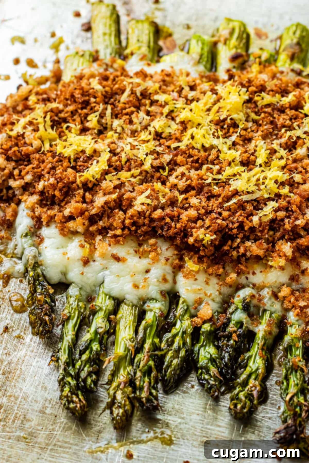 Close-up of Baked Cheesy Asparagus on a metal pan, ready to serve.