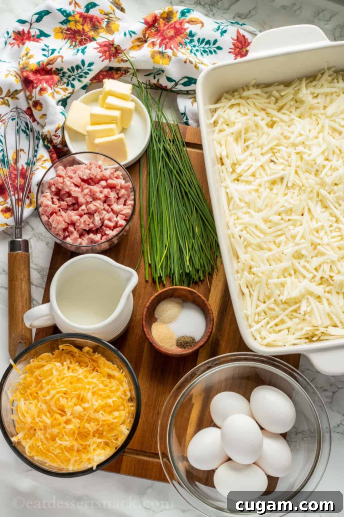 Ingredients for ham and cheese hash brown casserole on wood cutting board.