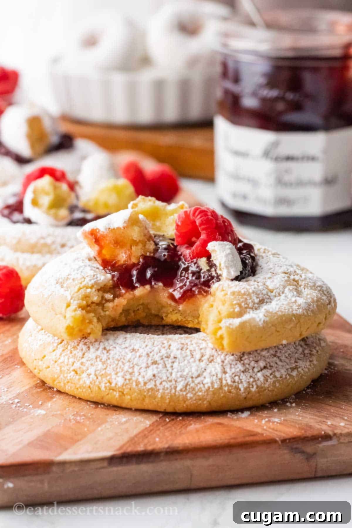 Baked Raspberry Donut Crumbl Cookie with bite removed on wood board.
