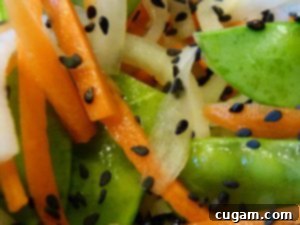 Vibrant Daikon and Carrot Salad with snow peas and sesame seeds