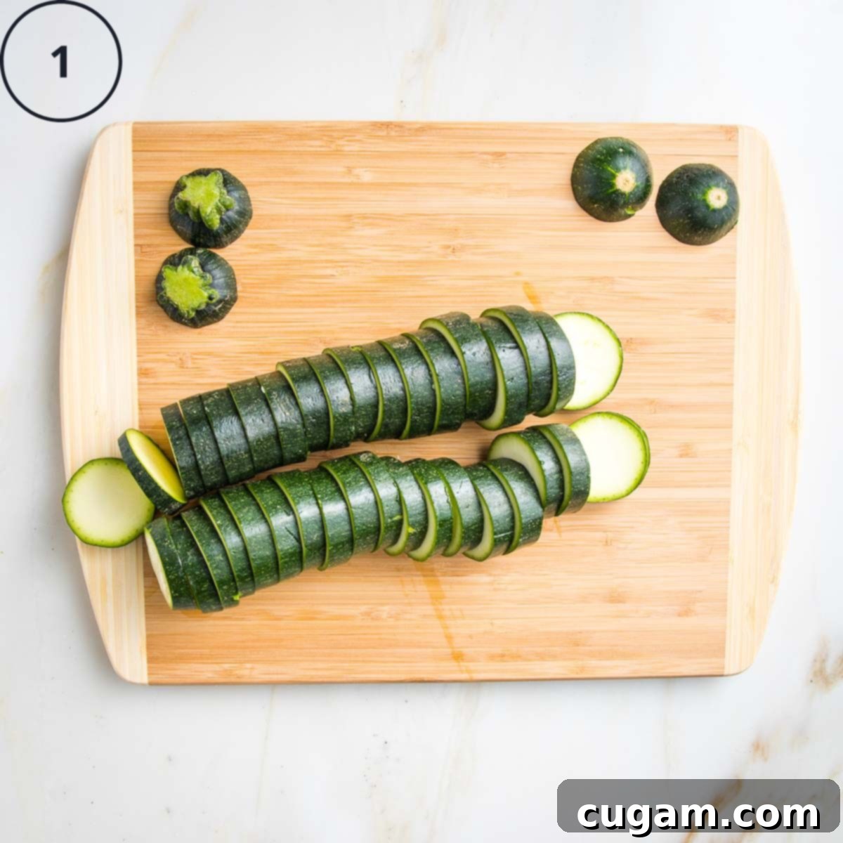 2 Zucchinis sliced into ¼" rounds on a wooden board.