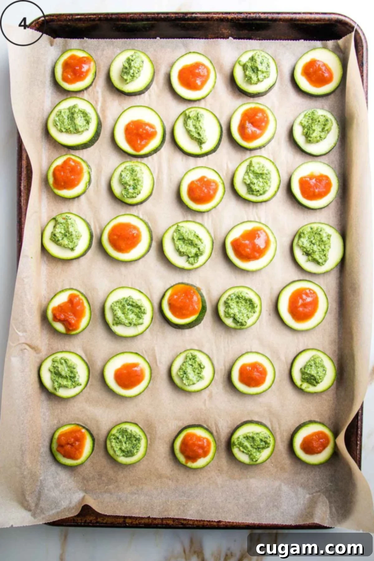 Quick Zucchini Pizza Bites 8 Baking tray with rows of sliced zucchini rounds topped with marinara or pesto.