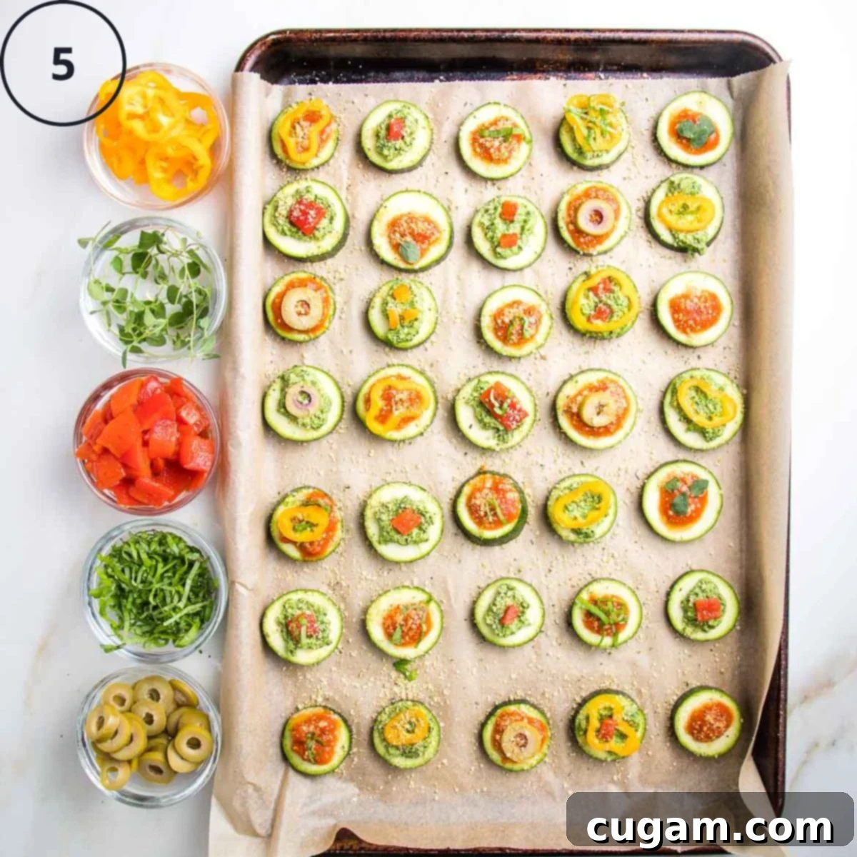 Quick Zucchini Pizza Bites 9 Baking tray of zucchini pizza bites with small dishes on the side with toppings.