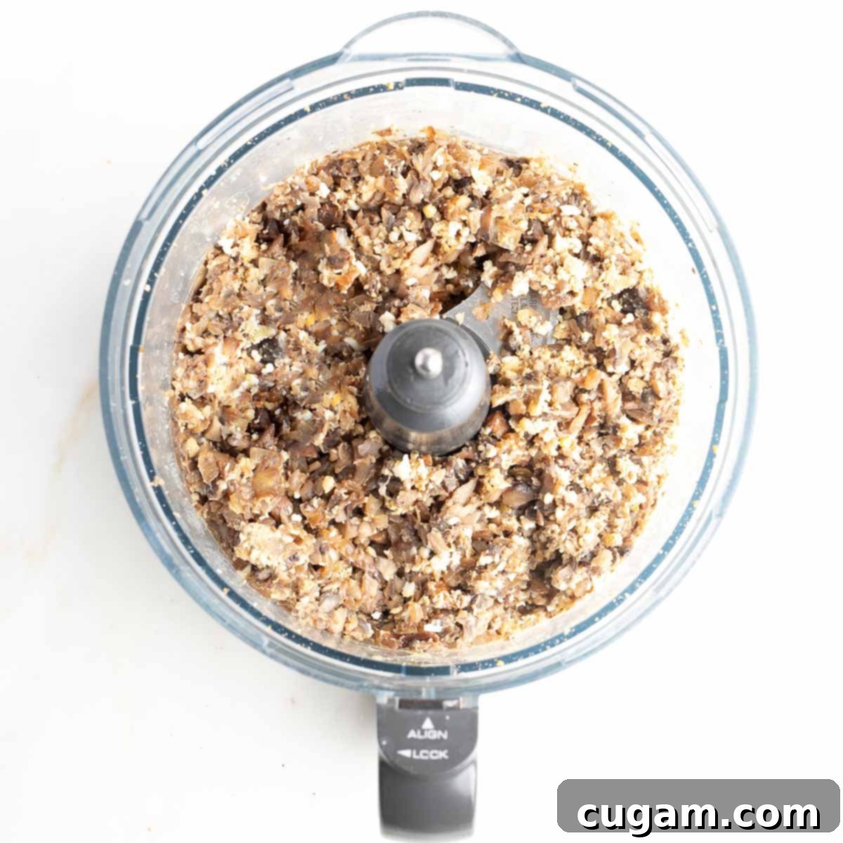 A close-up of the food processor bowl after blending, showing the completed mock chopped liver—a rich, brown spread with a textured consistency from the mushrooms, onions, walnuts, and boiled eggs, resembling traditional chopped liver.