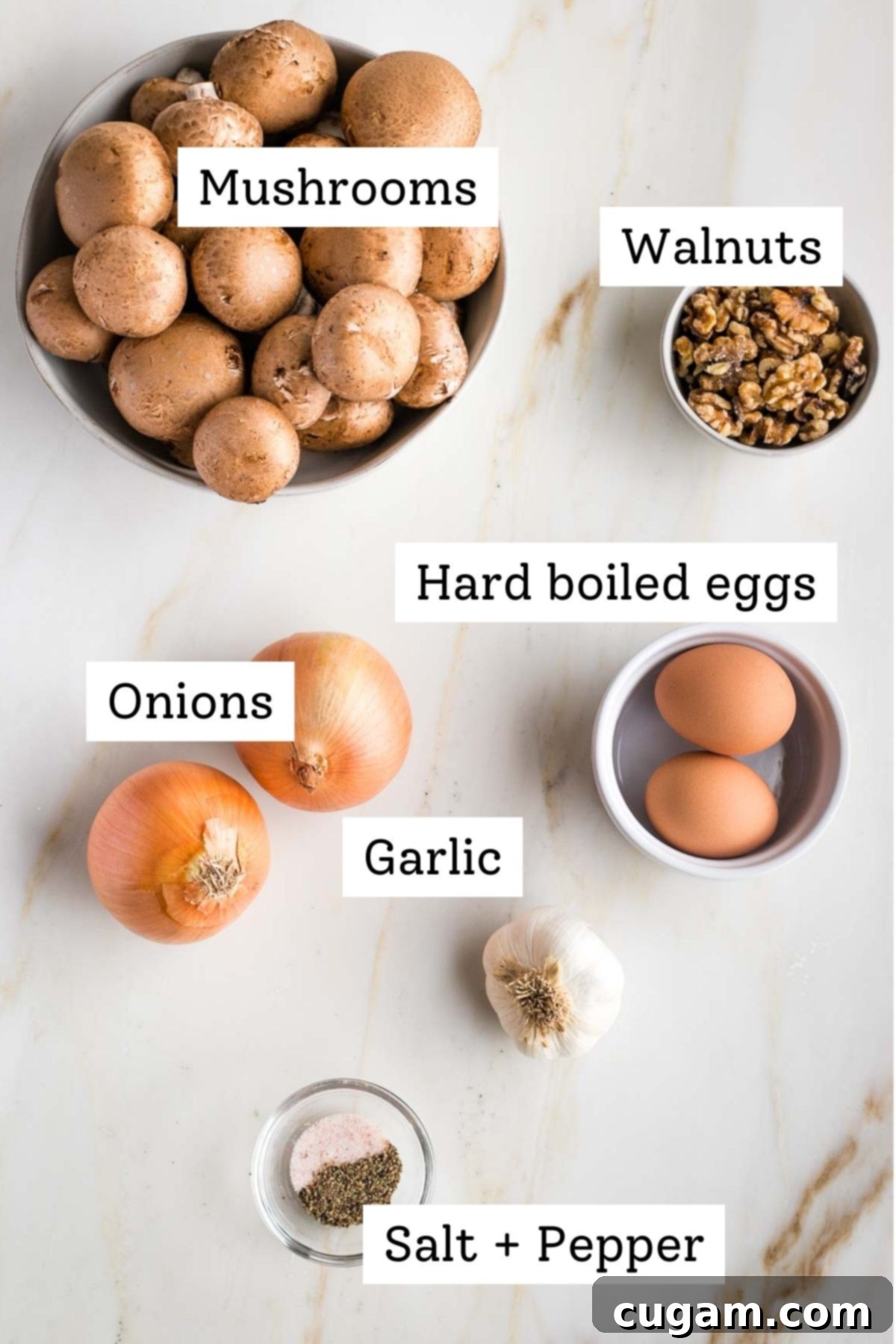 A close-up shot of key ingredients for vegetarian chopped liver, including fresh portobello mushrooms, whole walnuts, peeled hard-boiled eggs, and diced onions, neatly arranged to highlight their textures and readiness for cooking.