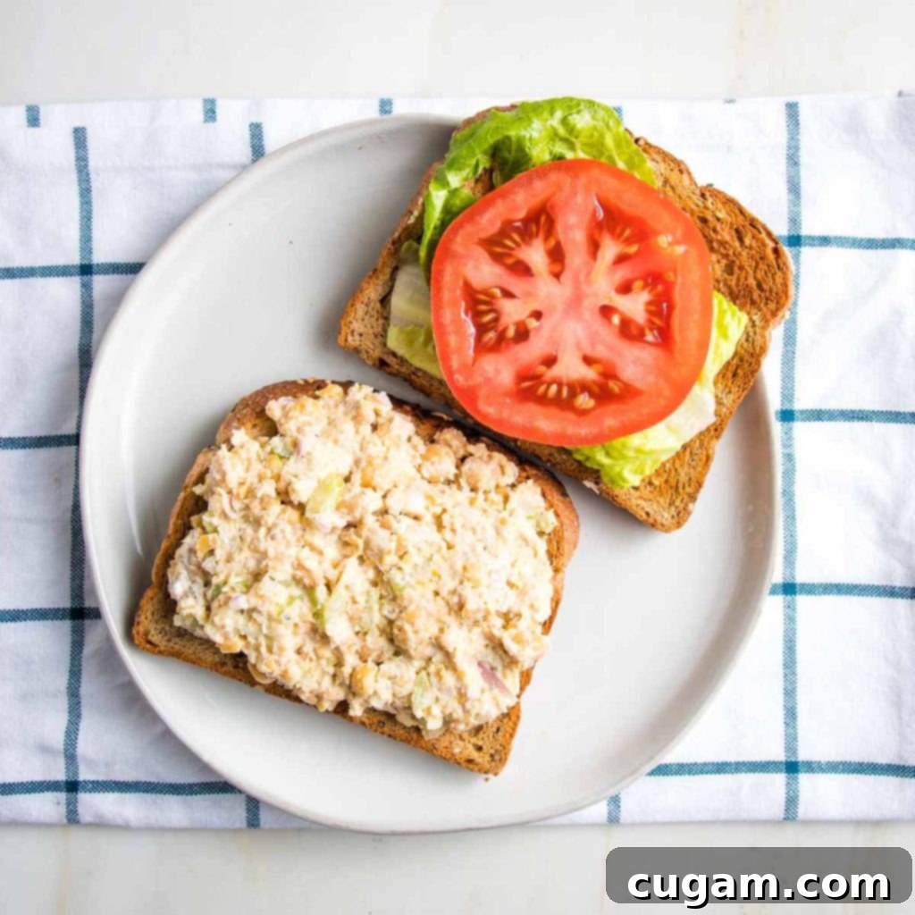 Open sandwich, one half with vegan tuna, the other with lettuce and tomato.