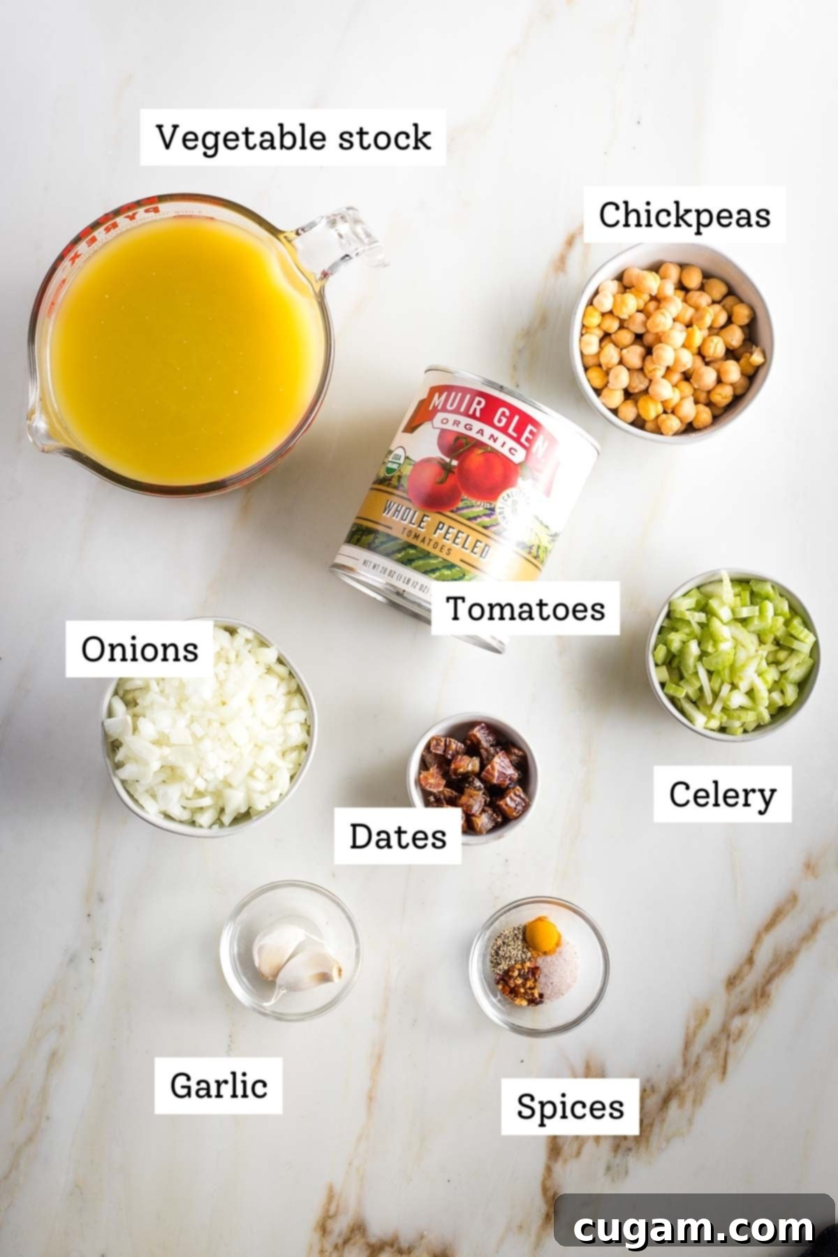 Creamy Dairy-Free Tomato Soup Recipe 4 Labeled ingredients for dairy-free tomato soup: vegetable stock, canned tomatoes, chickpeas, onions, dates, celery, garlic, and spices.