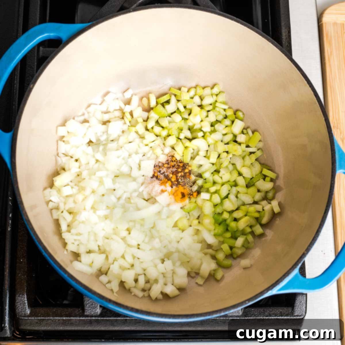 Creamy Dairy-Free Tomato Soup Recipe 5 Dutch oven with chopped onions, celery, and a sprinkle of spices.