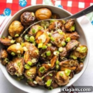 A bowl of creamy grilled potato salad with fresh scallions.