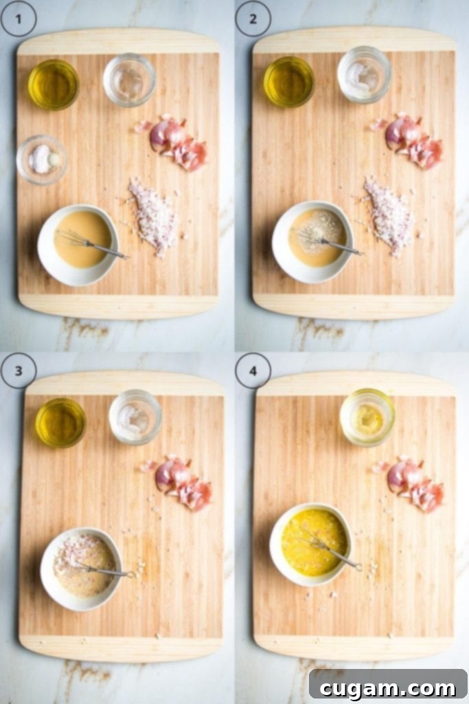 A small glass bowl filled with a freshly prepared shallot vinaigrette, resting on a white surface next to a mini whisk, showcasing the creamy emulsified texture of the dressing.