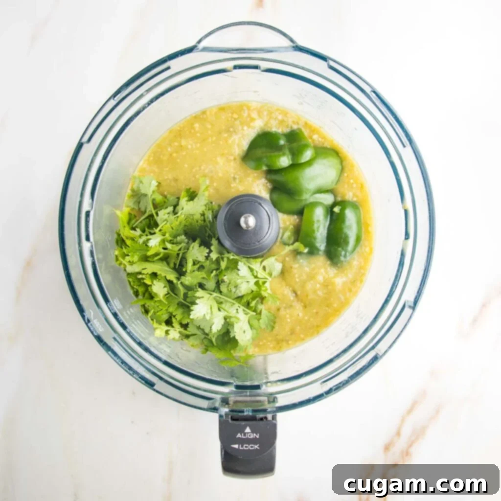Zesty Roasted Tomatillo Salsa 10 Fresh cilantro and lime being added to the blended salsa in a food processor.