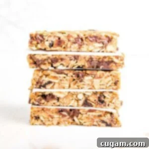 A stack of crunchy granola bars, with parchment paper in between layers.