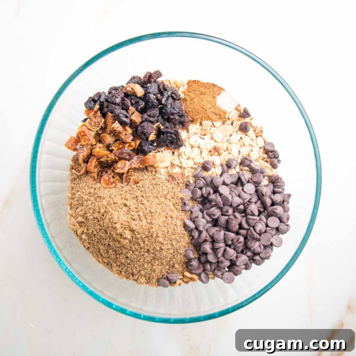 Chocolate chips, flax, raisins and cinnamon in a bowl of oats and nuts.
