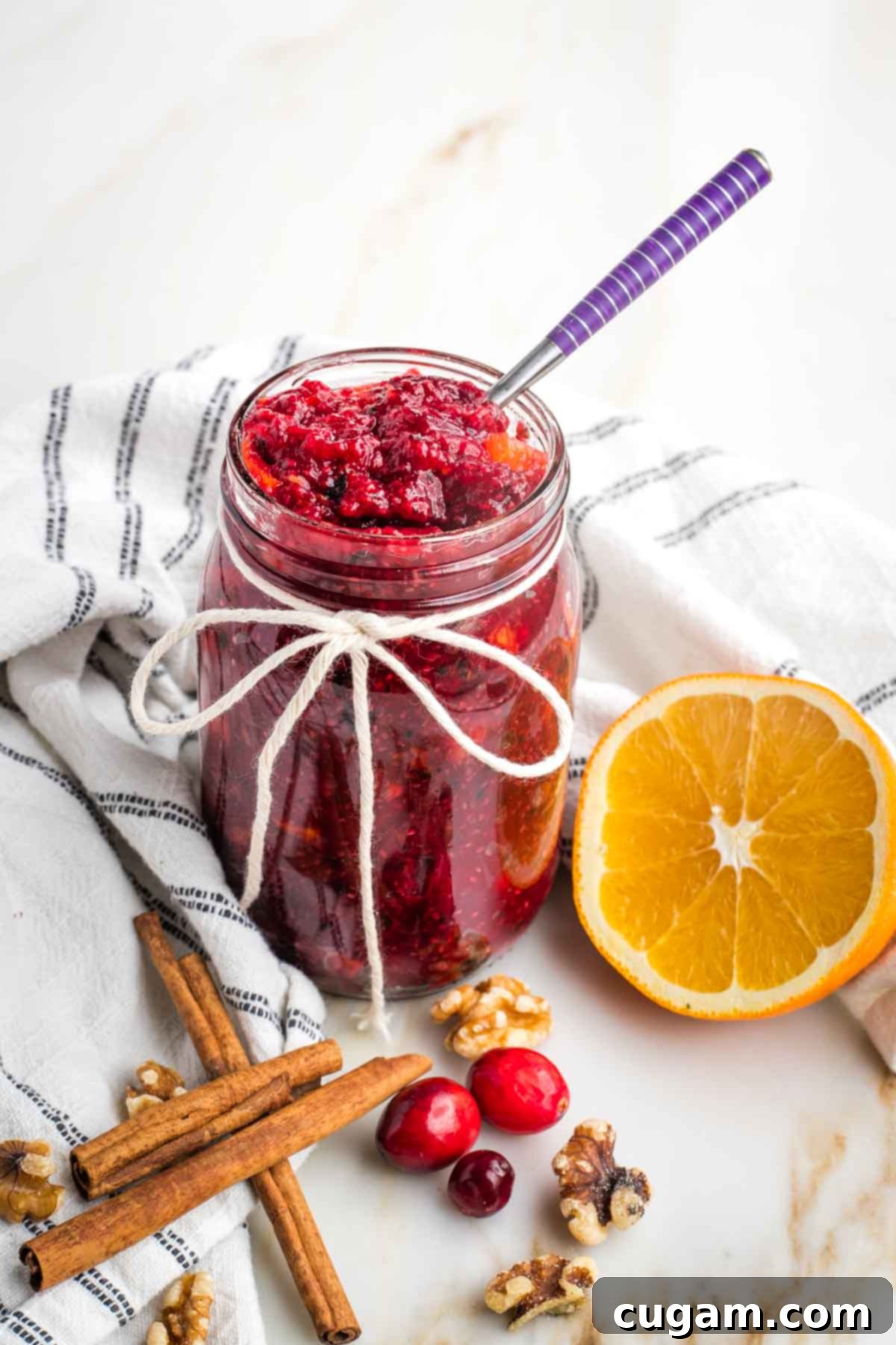Cooked cranberry sauce in a bowl with a spoon.