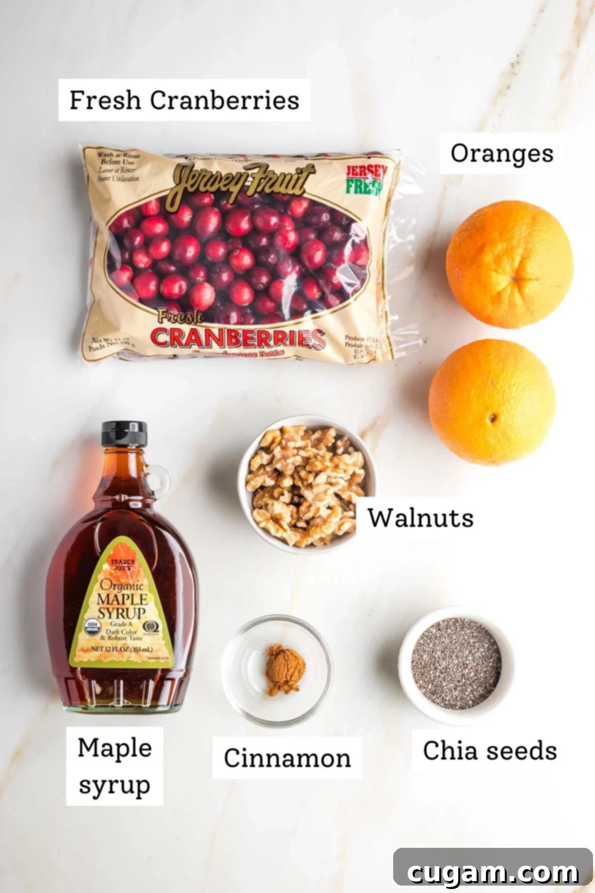 Labeled ingredients for cranberry sauce: fresh cranberries, oranges, maple syrup, walnuts, cinnamon and chia seeds.