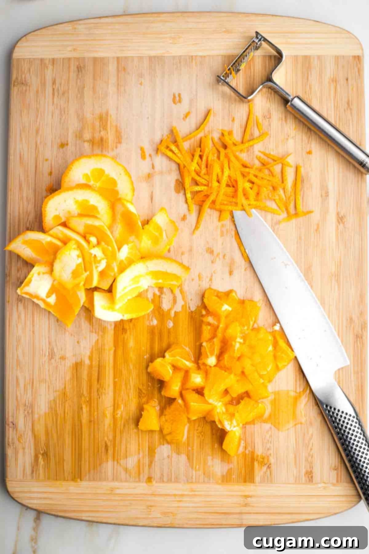 An orange showing long strips of zest, the remaining peel and the flesh roughly chopped.