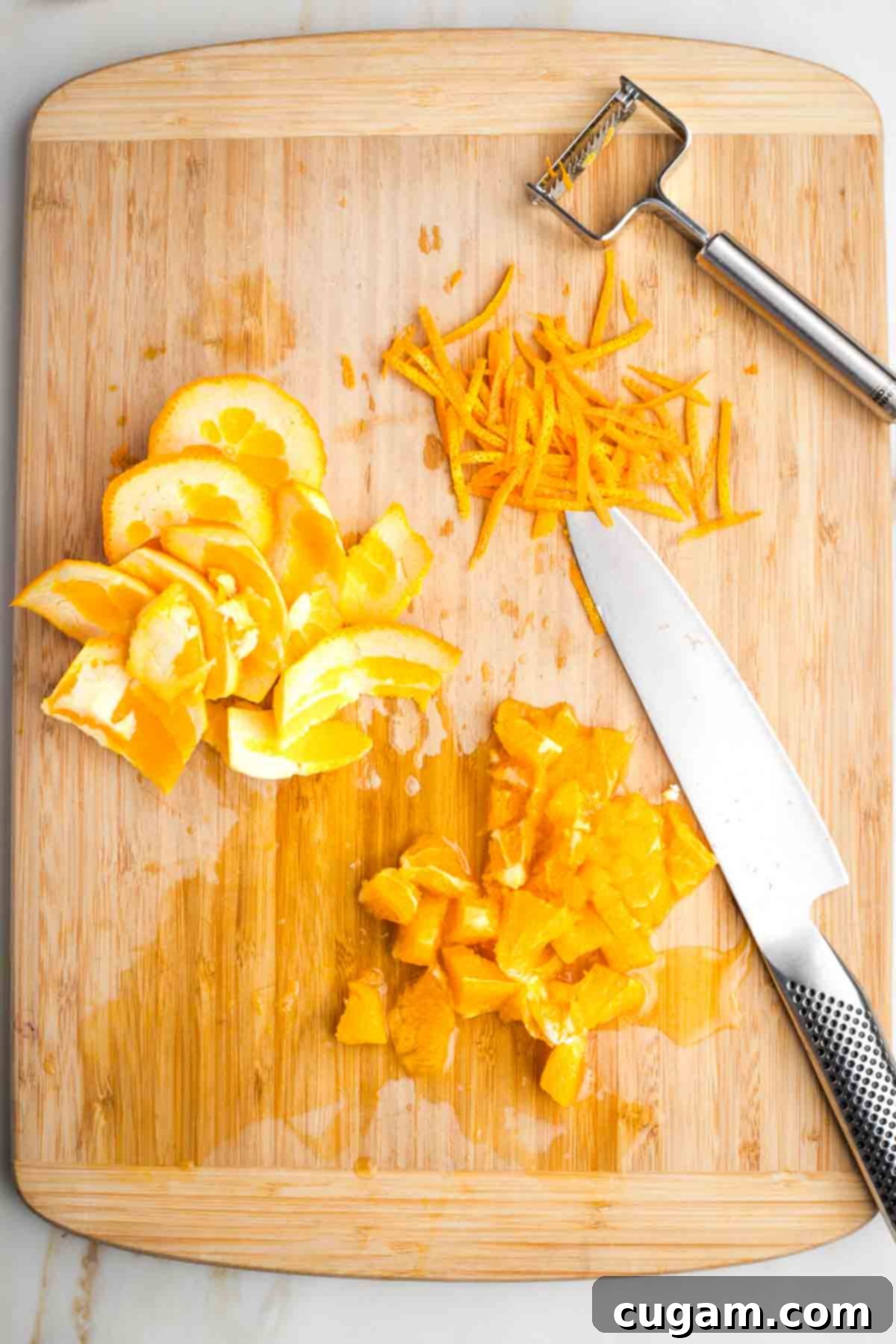 An orange showing long strips of zest, the remaining peel and the flesh roughly chopped.