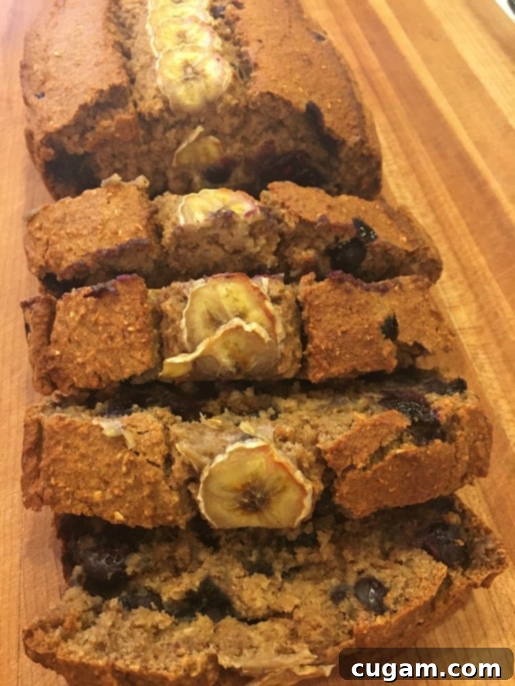 Freshly baked healthy banana bread on a wooden cutting board, with several slices cut and ready to serve.
